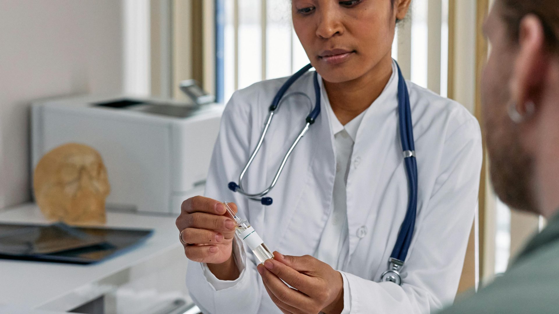 in-person doctor instructing a patient on how to use medicine
